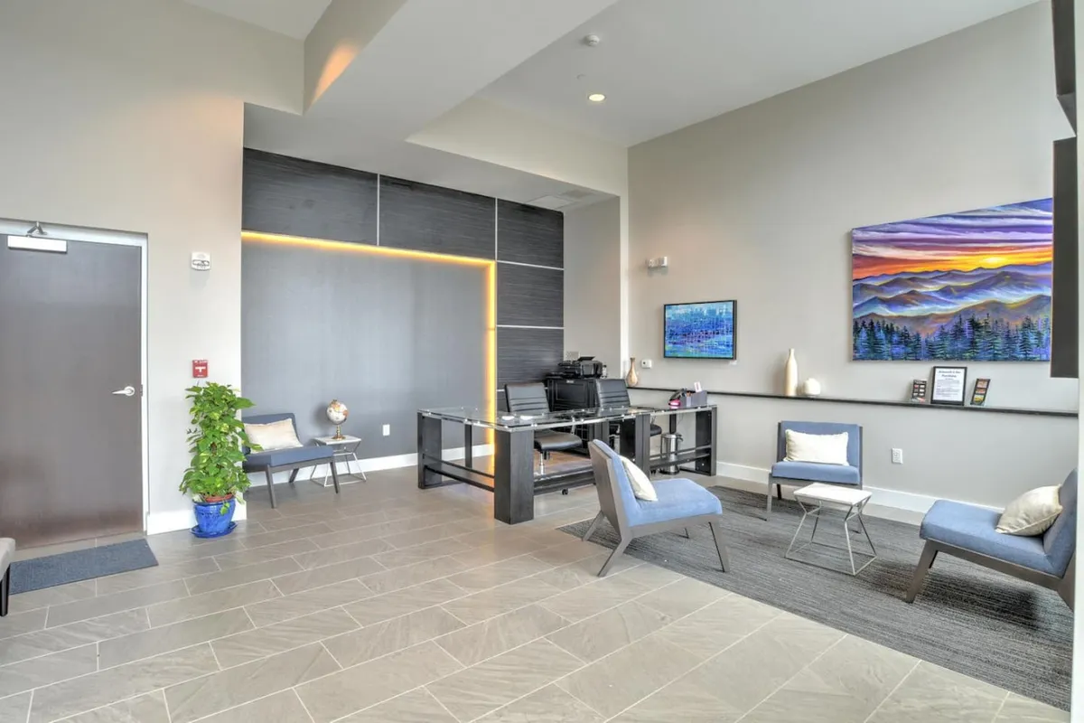 This image captures the building's inviting reception area, featuring a modern reception desk, tasteful artwork, and a comfortable seating area. The professional and organized atmosphere echoes the sense of security and managed services described in the section.